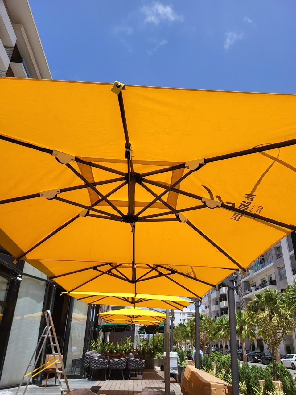 Parasols suspendus jaunes sur la terrasse d'un restaurant
