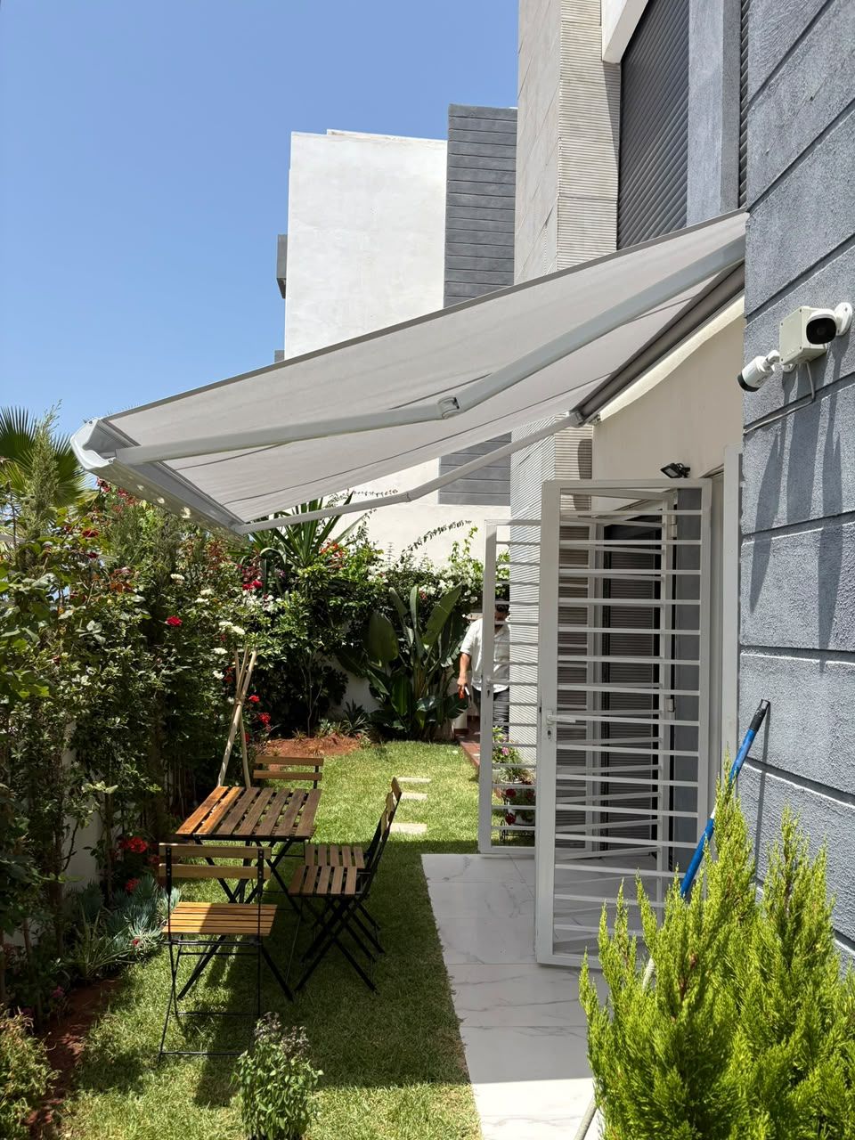 Store banne gris au-dessus d'un jardin