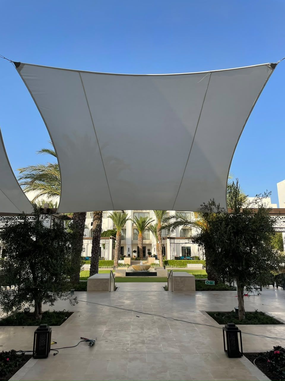 Voile d'ombrage blanche tendue au-dessus d'une allée